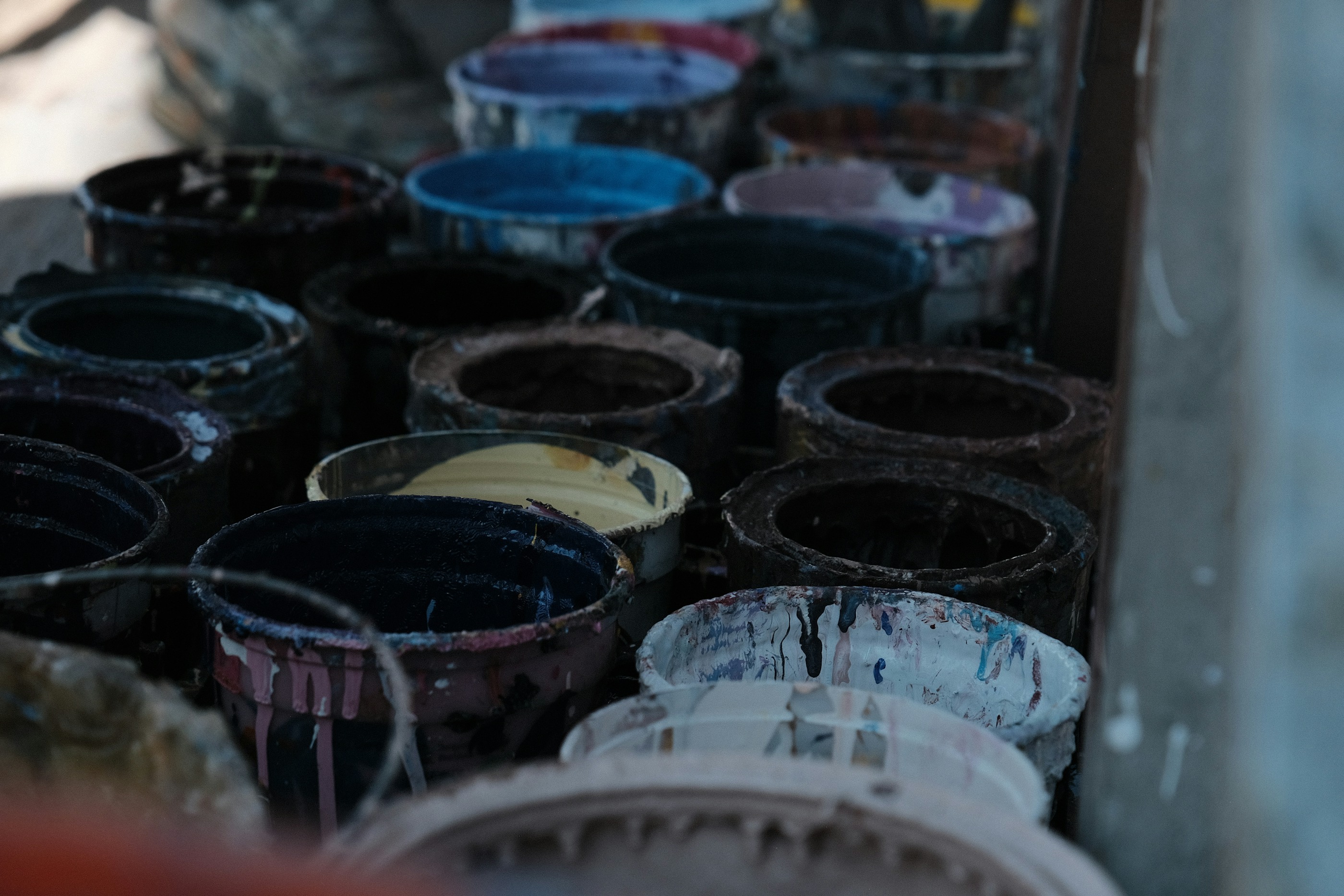 High-end paint and coatings production floor with stacked buckets and controlled industrial lighting